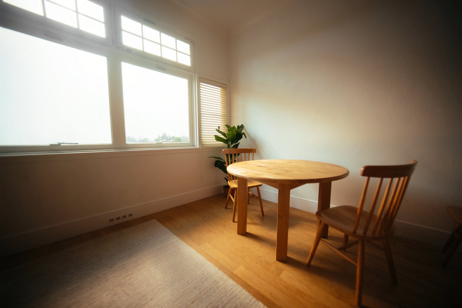 Coin de pièce clair avec une table ronde en bois près d'une fenêtre