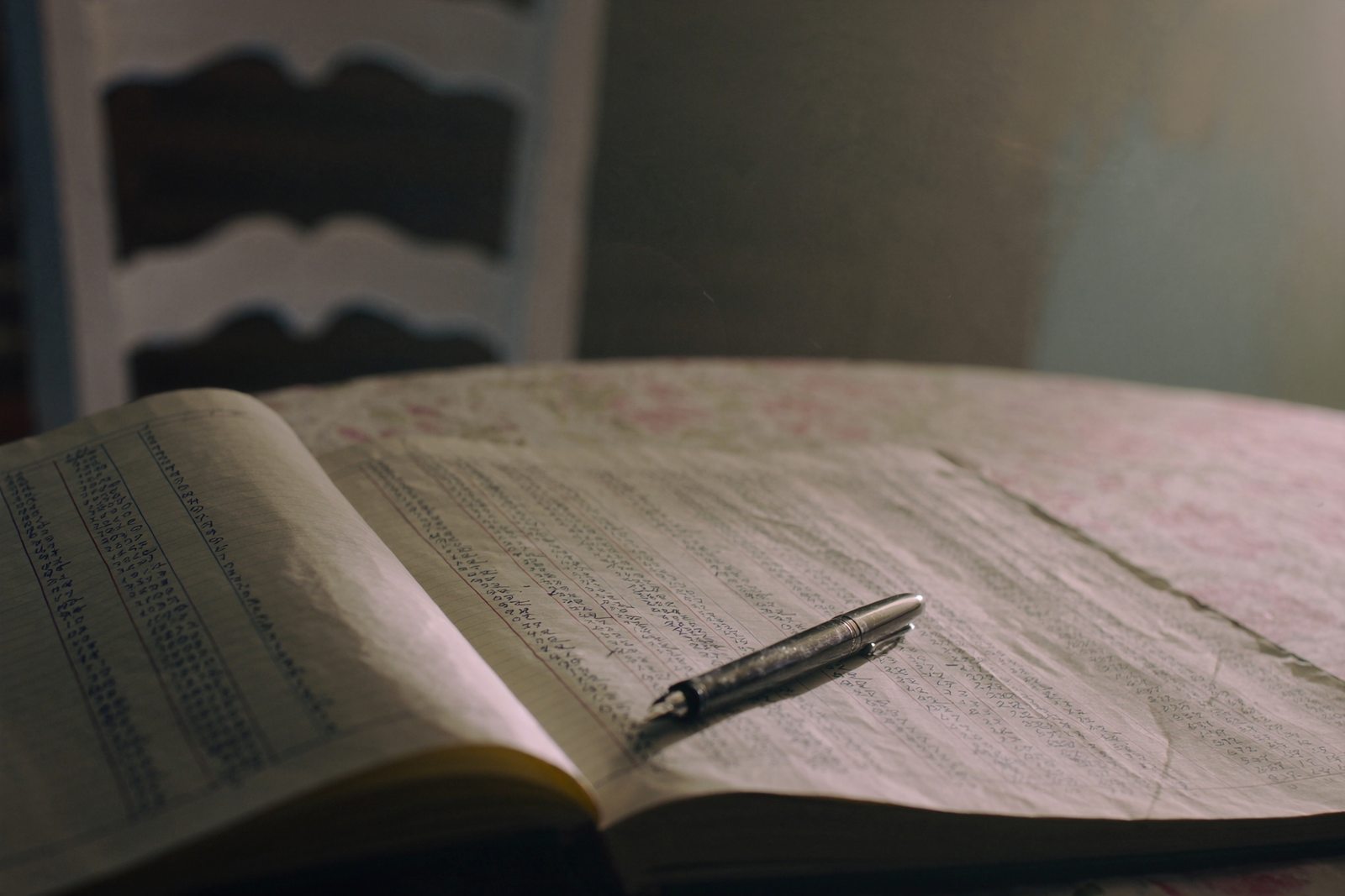 Un livre ouvert et un stylo posés sur une table de bois