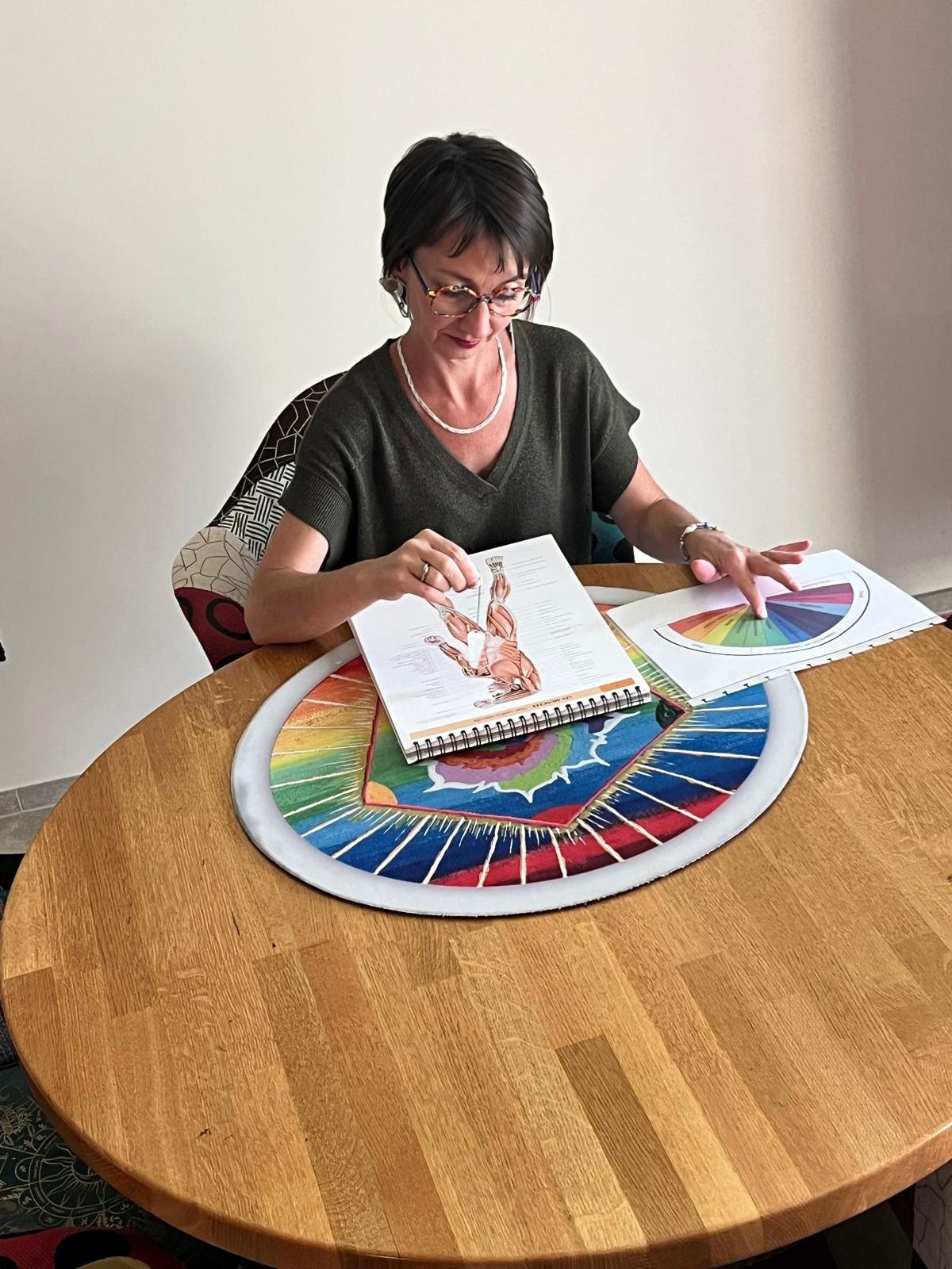 Émilie Haras à sa table de travail, la roue chromatique et la planche devant elle