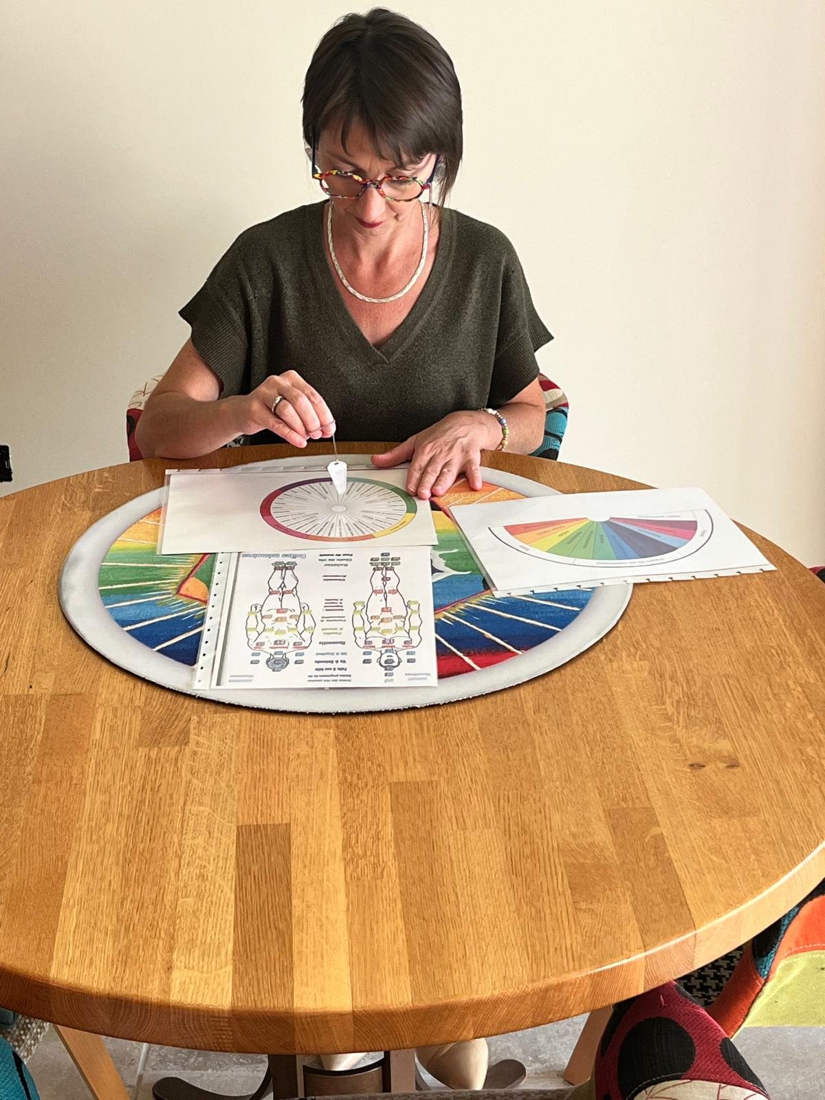 Le pendule d'Émilie Haras au-dessus de sa planche de travail